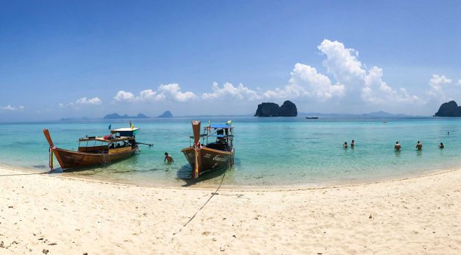 Shows two long tail boats on a beach in Koh Lanta - The best places to stay in Koh Lanta
