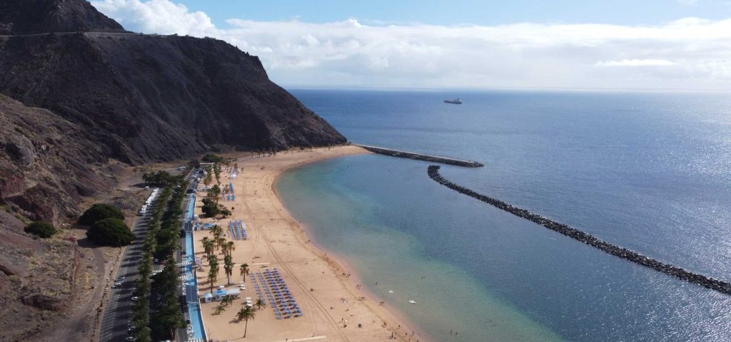 Shows a drone shot of a beach in Gran Canaria